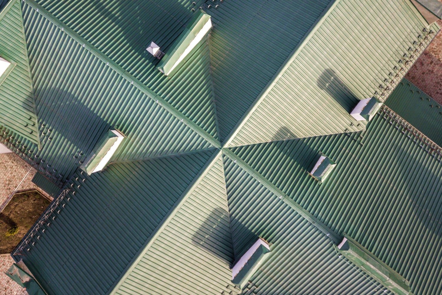 Top aerial view of building green shingle tiled roof construction. Abstract background, geometrical pattern.